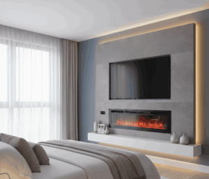 A modern bedroom media wall featuring a large, wall-mounted TV centered above a slim, rectangular electric fireplace with glowing flames. The media wall is finished in a grey stone or textured panel, accented with hidden LED strip lighting running vertically along the edges. A floating white shelf runs below the fireplace.
